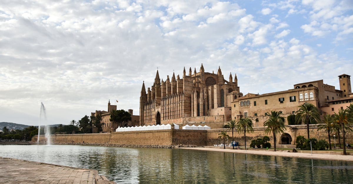 Mallorca väder i februari: katedralen i Palma vid strandpromenaden under en molnig vinterhimmel
