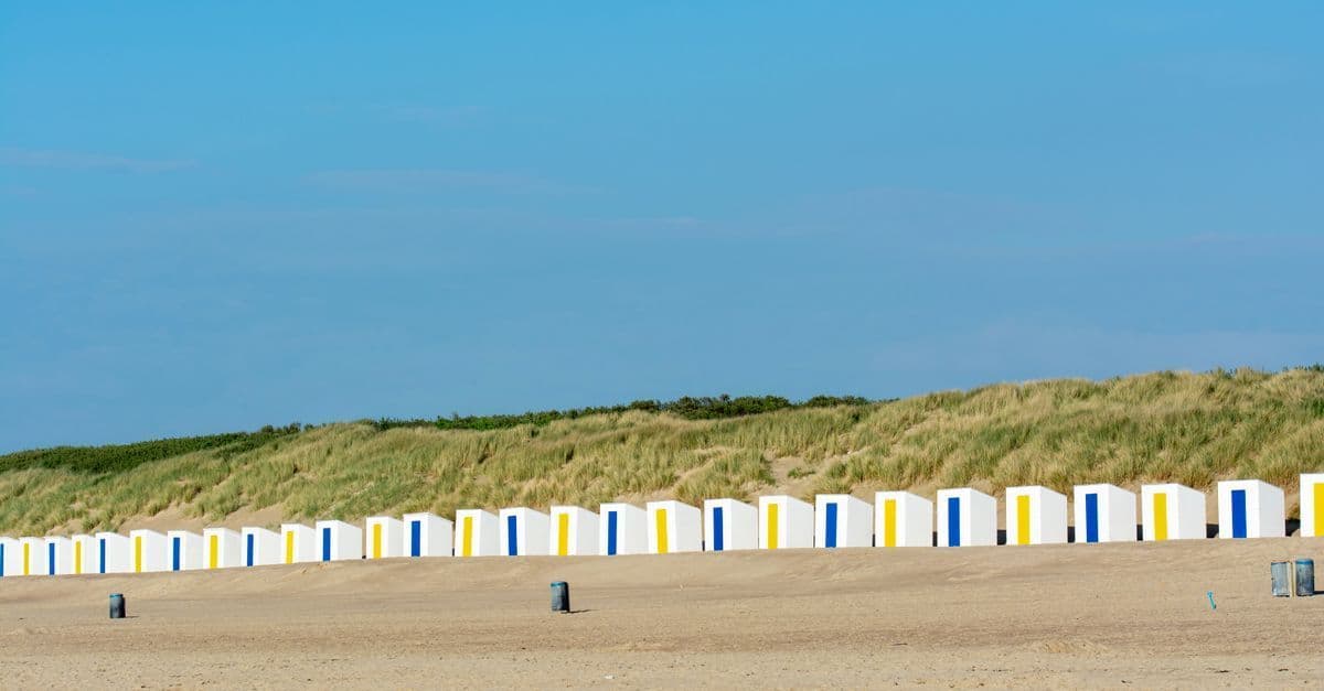 Kleurrijke strandhuisjes op het zonnige strand van Cadzand aan de Nederlandse kust.