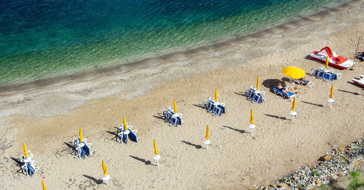 Turister slapper af under gule parasoller på en af Kretas varmeste sydlige sandstrande
