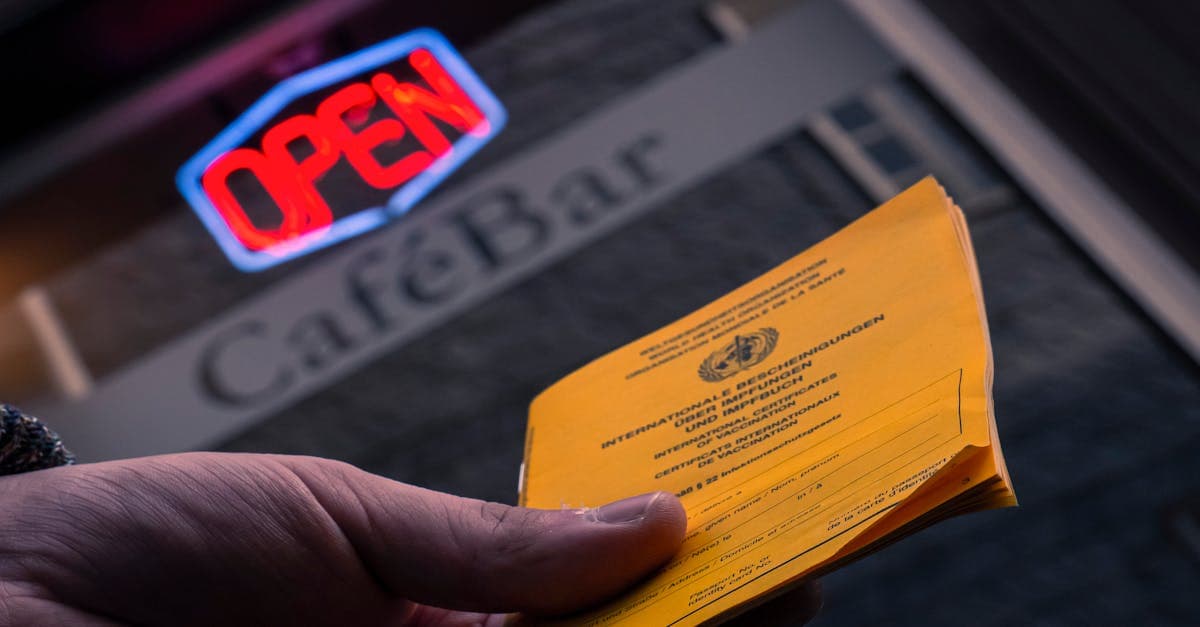 Hand hält Impfausweis vor Cafe symbolisiert Gelbfieber-Impfung Kosten und Krankenkassenerstattung