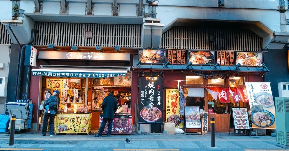 Vibrant tokyo grill yakiniku restaurant street scene with glowing lanterns and bustling evening crowds