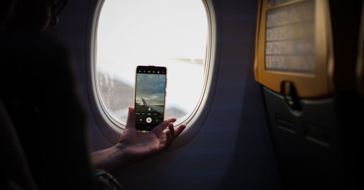 Viaggiatore che fotografa l'ala dell'aereo dal finestrino durante un volo prenotato su Google Flights.