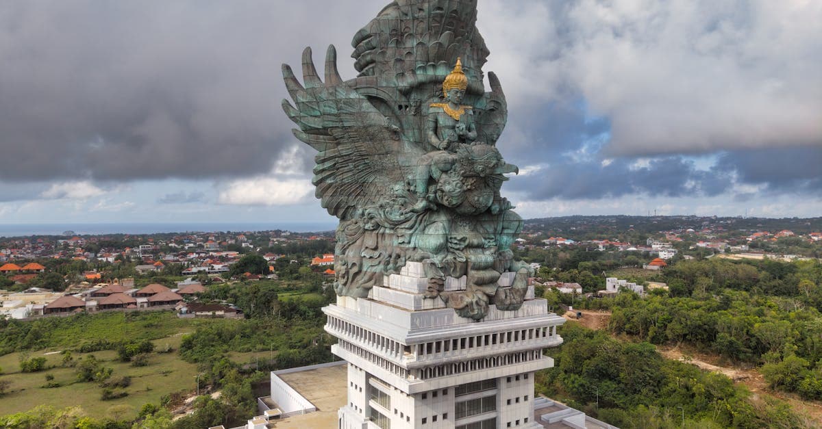 Estatua de Garuda Wisnu Kencana bajo un cielo dramático, símbolo cultural imprescindible al viajar a Bali