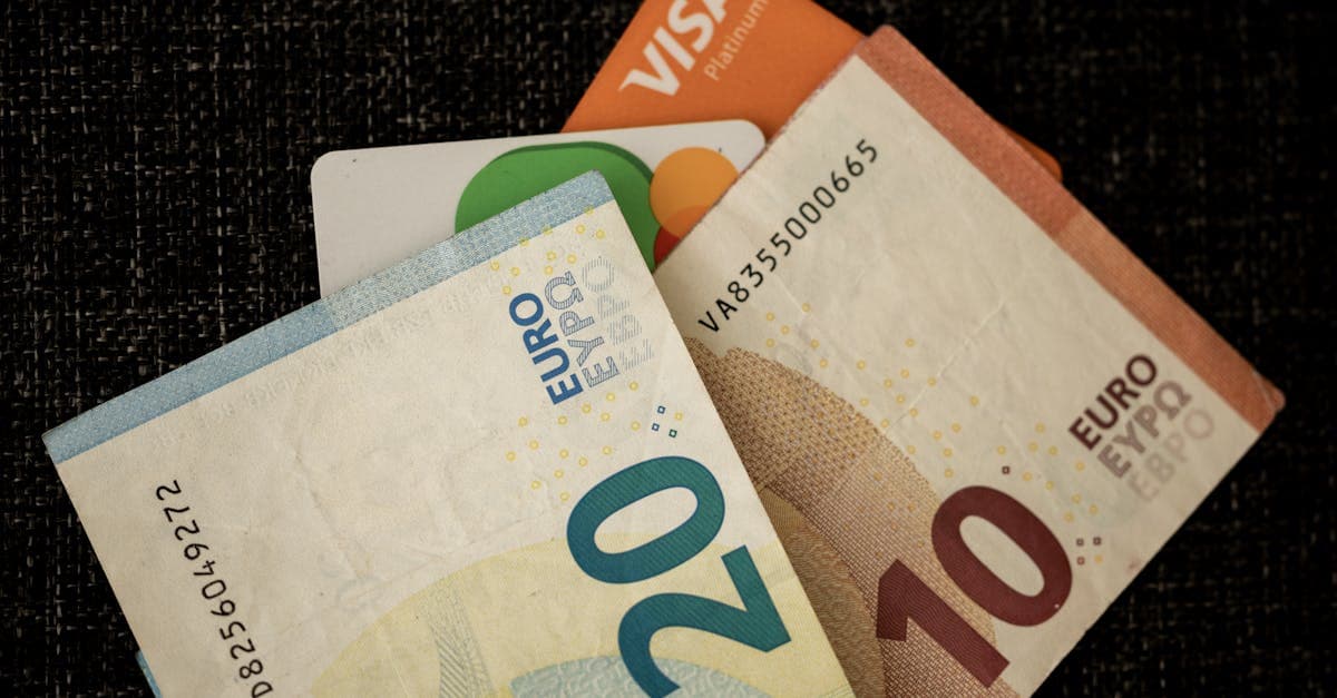 Uang euro dan kartu kredit di atas meja gelap, ilustrasi saldo rekening untuk visa schengen.